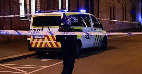 Un policier surveille la zone devant la synagogue la nuit, délimitée par un ruban de police.
