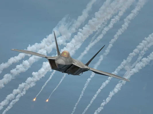 Un avion de combat tirant des leurres dans le ciel.