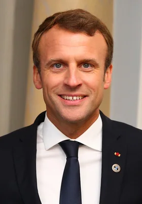 Portrait officiel d'Emmanuel Macron, président de la France, souriant en costume sombre.