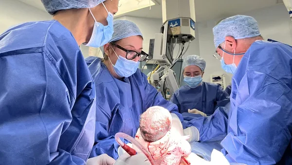 Équipe médicale lors de la naissance par césarienne d'un bébé issu d'une greffe