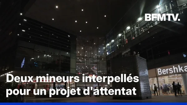 Vue nocturne d'un complexe moderne avec le texte 'Deux mineurs interpellés pour un projet d'attentat'.
