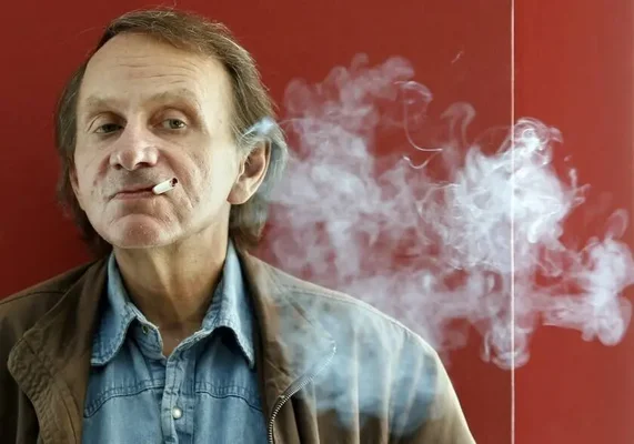 Michel Houellebecq fumant une cigarette sur fond rouge.