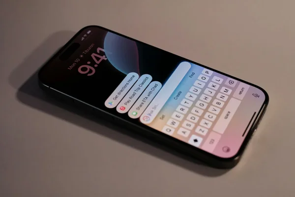 Écran d'un iPhone affichant l'heure, la localisation et le clavier avec suggestions.