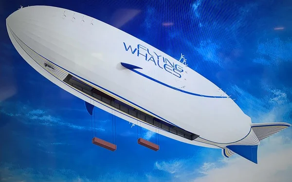 Le dirigeable géant de Flying Whales transportant deux conteneurs rouges, illustrant son concept de grue planétaire.