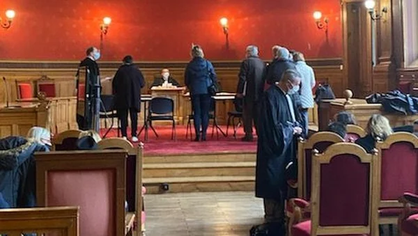 Une scène dans une salle d'audience où un juge préside la première audience sur la médiation civile en présence de plusieurs personnes masquées.