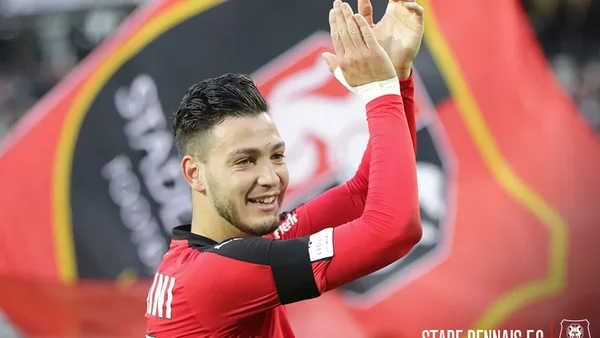 Ramy Bensebaini applaudissant avec son équipe nationale et son brassard de capitaine.