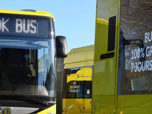 Des bus du réseau affichant la gratuité totale, stationnés sous un ciel dégagé.