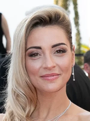 Priscilla Betti en portrait coiffée de blondes vagues lors d'un événement.