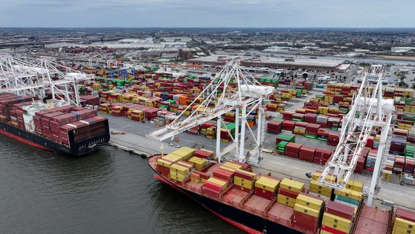 Deux hommes en costume se serrent la main sur un escalier tapis rouge.