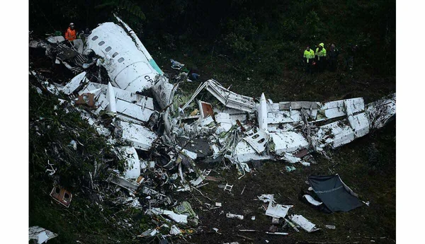 Épaves d'un avion dans une forêt examinées par des équipes de sécurité.