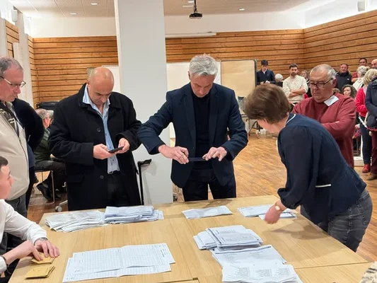 Groupe de personnes examinant des documents sur une table.