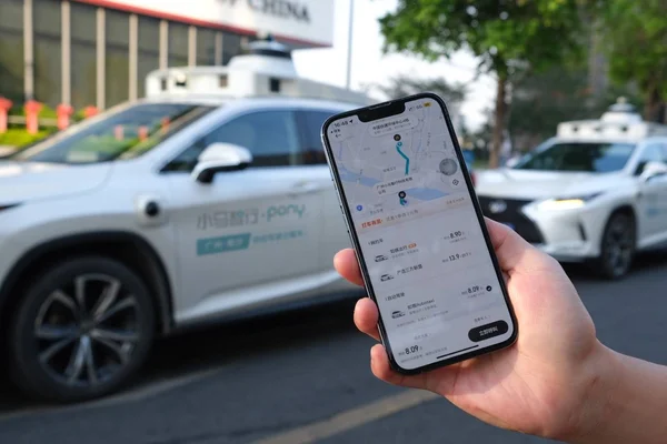 Interface de l'application Pony.ai avec des taxis autonomes en arrière-plan à Shenzhen.