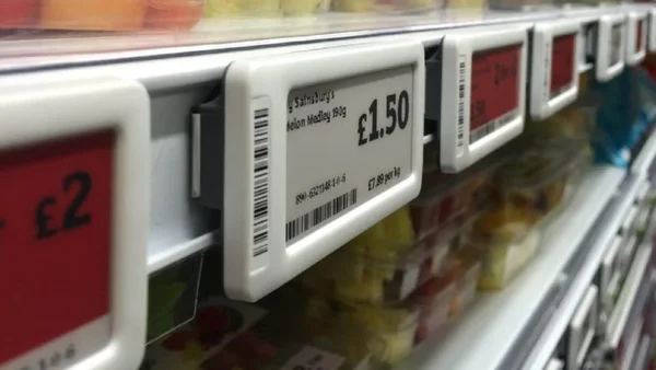 Panneaux de prix Walmart affichant des tarifs bas sur des présentoirs de vêtements dans un magasin.