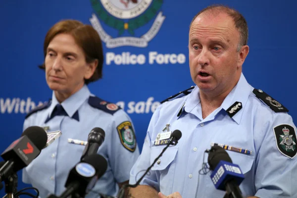 Deux policiers se tiennent devant des microphones lors d'une conférence de presse.