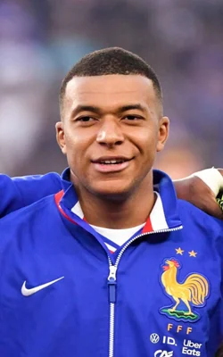 Kylian Mbappé portant la veste officielle bleue de l'équipe de France avec sponsors.