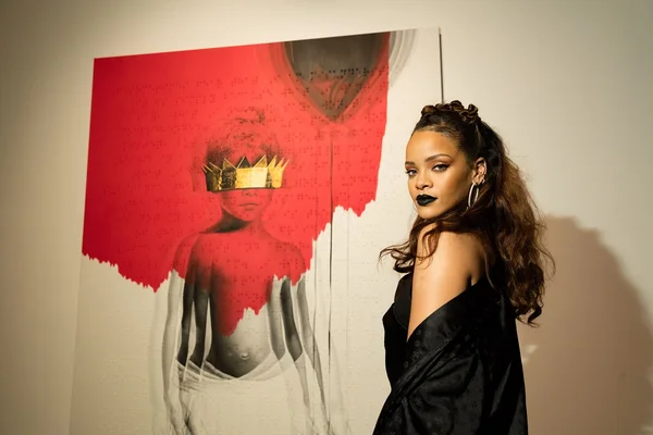 Rihanna posant devant une œuvre d'art figurant une couronne dorée.