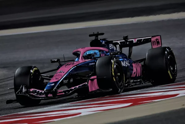 Une Red Bull Racing mène la course devant des tribunes pleines de spectateurs sous un ciel dégagé.