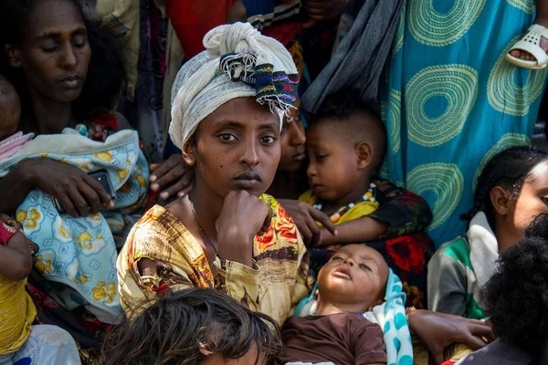 Un groupe de personnes, dont une femme au centre entourée d'enfants, lors de la crise.