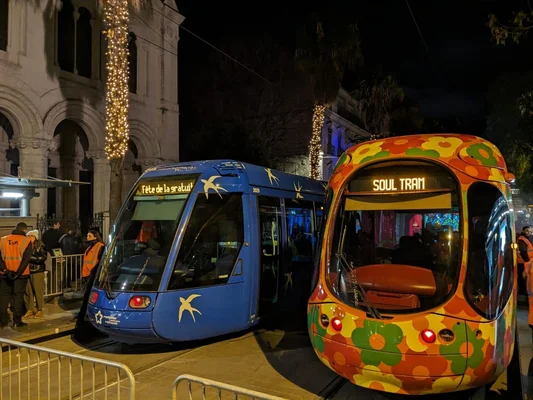 Célébration nocturne avec des trams dont l'un affiche 'Fête de la gratuité'.