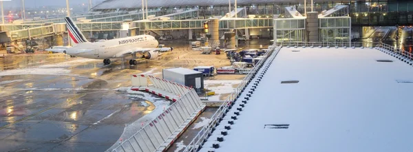 Un avion Air France stationné sur le taxis enneigé près du terminal