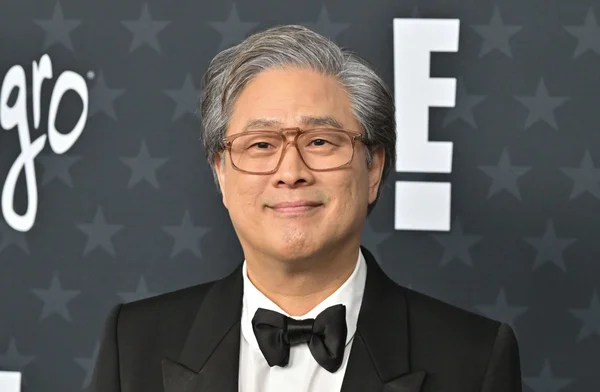 Une femme en robe sur le tapis rouge devant le Grand Auditorium Louis Lumière.