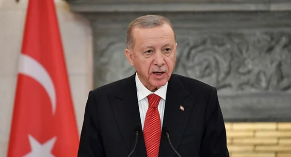 Le président Erdoğan à la tribune, avec le drapeau turc visible à sa gauche.