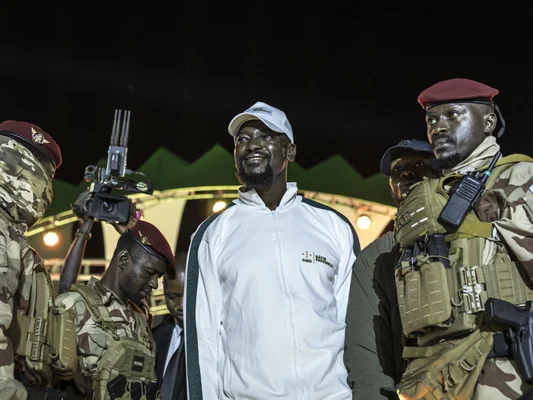 Un homme en boubou et une femme lors d'un événement public sous un dais.