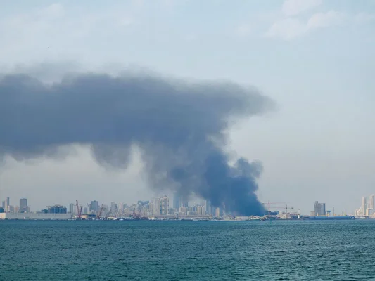Ville au crépuscule avec fumée et flammes émergeant d'un bâtiment