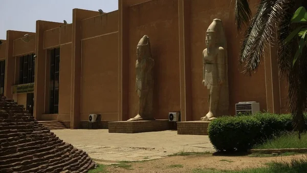L'entrée d'un site historique gardée par d'anciennes statues de pharaons.