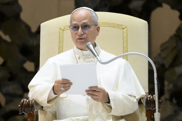 Le pape Léon XIV assis dans un fauteuil, tenant un document et s'exprimant au micro.