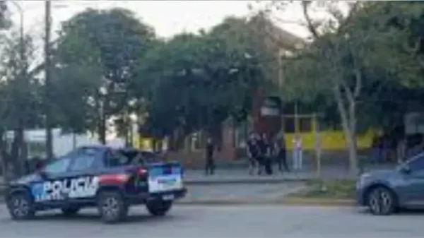 Véhicule de police dépêché sur les lieux d'un tiroteo dans une école argentine, devant un bâtiment jaune entouré d'arbres