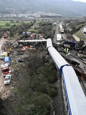 Secouristes intervenant sur les wagons détruits après la tragédie ferroviaire en Grèce.