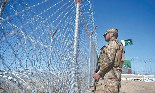 Un soldat à côté d'une clôture barbelée marquant la frontière avec le Pakistan.