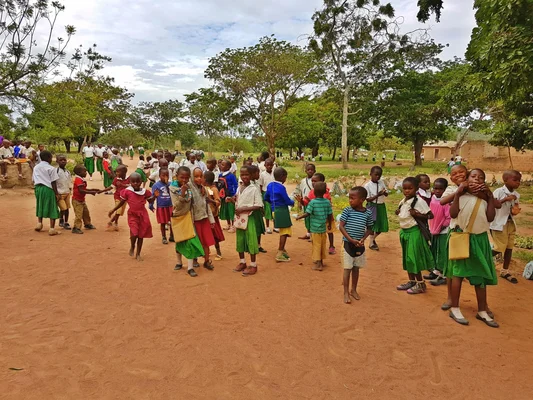 Un groupe d'enfants se réunit sur un terrain vague dans un cadre rural.
