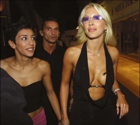 Loana Petrucciani arborant une robe noire et des lunettes violettes lors d'une sortie nocturne.