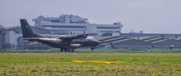 Avion de transport militaire sur une piste, probablement un C-130 Hercules