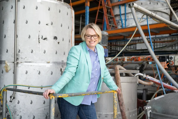 Une professionnelle devant les cuves de fermentation industrielles.