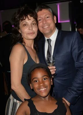 Isabelle Mergault accompagnée d'un homme et d'un enfant lors d'une soirée publique.