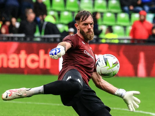 Alexandre Oukidja en action, bottant un ballon lors d'un match.