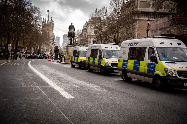 Deux policiers en gilet haute visibilité près d'une fourgonnette dans une rue nocturne.
