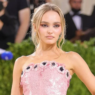 Lily-Rose Depp en robe rose strapless lors d'un événement mondain