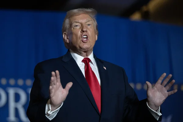 Haut fonctionnaire ou responsable en costume expliquant une décision lors d'une conférence de presse.