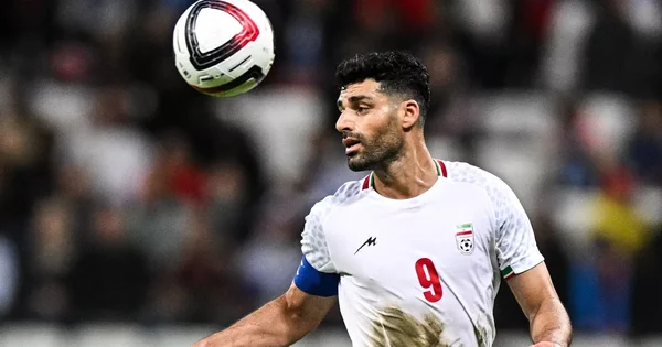 Le capitaine de l'équipe d'Iran focalisé sur le ballon lors d'une rencontre internationale.