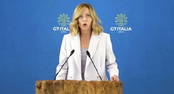 Conférence de presse lors du G7 ITALIA 2024 sur fond bleu.