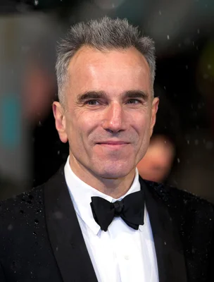 Daniel Day-Lewis en tenue de gala, souriant face à la caméra.