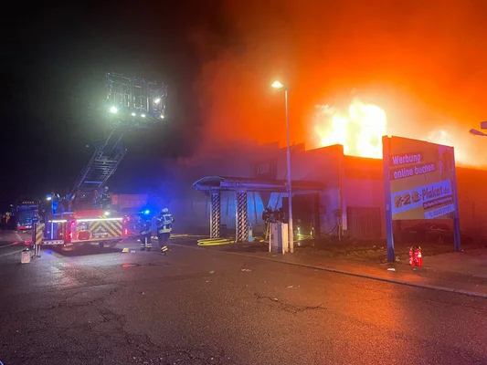 Intervention des pompiers de nuit sur l'incendie du K Club à Kehl, avec des flammes visibles et la grande échelle déployée.