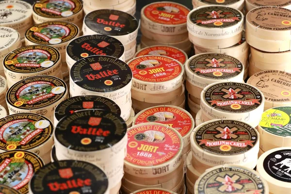 Un empilement de meules de fromage de diverses marques normandes.