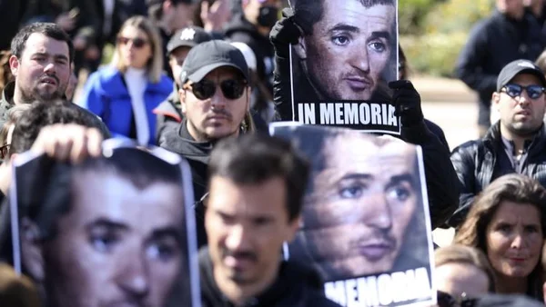 Participants levant des affiches 'IN MEMORIA' lors d'un rassemblement en mémoire d'Yvan Colonna.