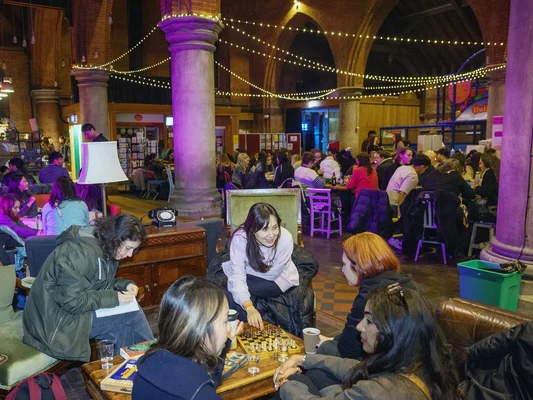 Plusieurs femmes jouant aux échecs autour d'une table en bois lors d'un événement de détournement numérique.