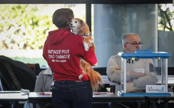 Un électeur avec son chien devant un bureau de vote à La Rochelle lors du premier tour des élections municipales.